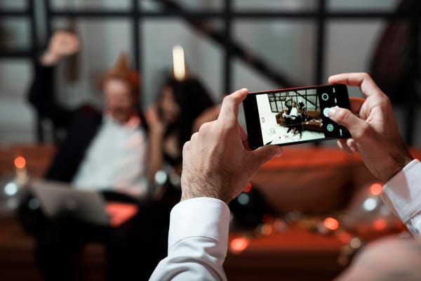 Guests at a wedding using their smartphones to capture and share special moments with the couple