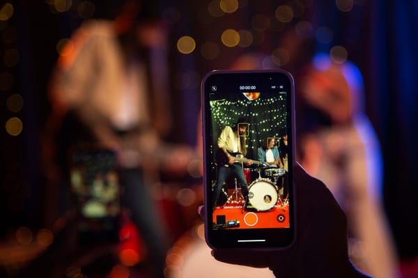 Guests happily capturing wedding moments with their smartphones at a modern event